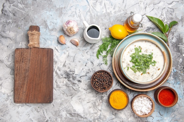 Vista superior saborosa sopa de iogurte dovga com verduras em prato de sopa de leite branco claro