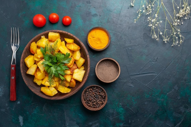 Vista superior saborosas batatas cozidas com temperos em fundo azul escuro