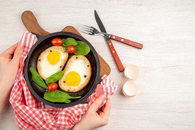 Vista superior saborosas torradas de ovos dentro da panela com ovos frescos em fundo branco prato cor pão café da manhã refeição chá comida almoço