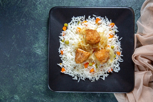 Vista superior saboroso arroz cozido com feijão e carne dentro do prato na mesa escura
