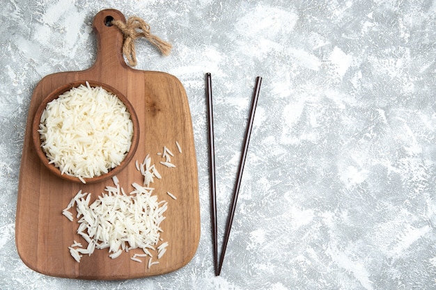 Vista superior saboroso arroz cozido dentro de um prato marrom no branco