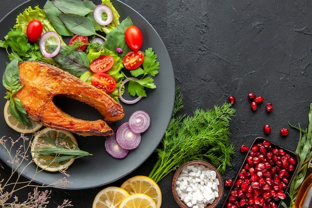 Vista superior saboroso peixe cozido com legumes frescos em uma mesa escura de frutos do mar com pratos de comida de carne.