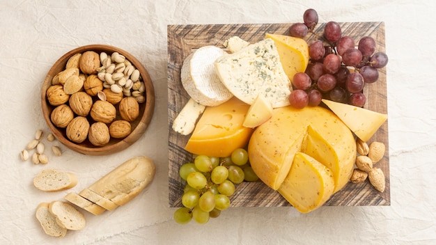 Foto grátis vista superior saboroso queijo com uvas e nozes