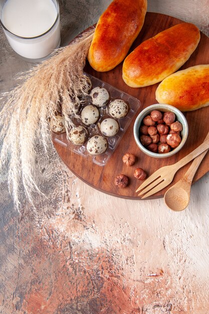 Vista superior saborosos bolos quentes assados com copo de leite na superfície leve refeição pastelaria bolo comida forno cor torta de massa