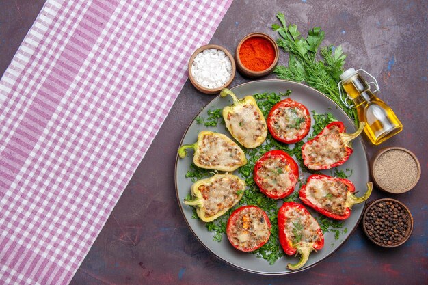 Vista superior saborosos pimentões deliciosa refeição cozida com carne e verduras na mesa escura refeição jantar prato pimenta picante