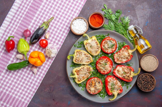 Vista superior saborosos pimentões deliciosa refeição cozida com carne e verduras na superfície escura jantar prato pimenta comida picante