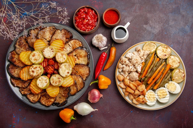 Vista superior saborosos vegetais assados, batatas e berinjelas em fundo escuro refeição forno cozinhando cozer cor vegetal