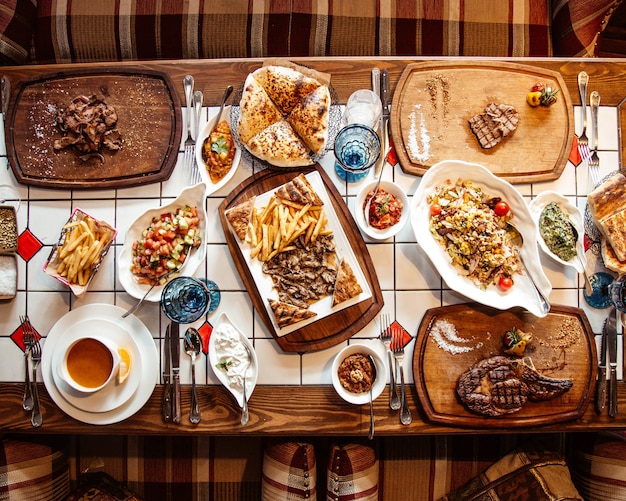 Foto grátis vista superior servida mesa com várias refeições e lanches