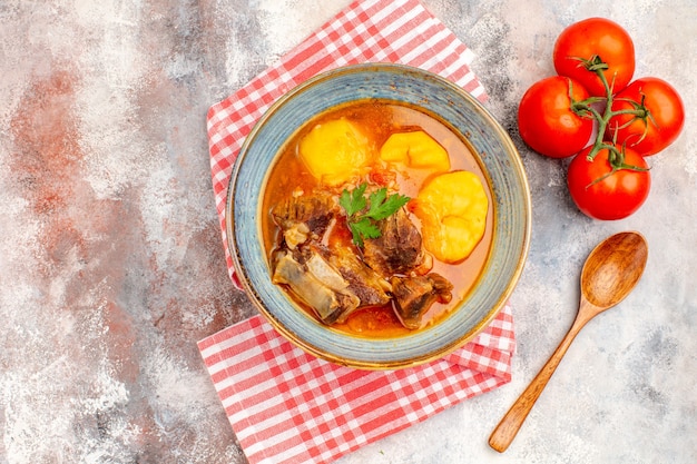 Vista superior sopa bozbash caseira toalha de cozinha tomate colher de pau na superfície nua