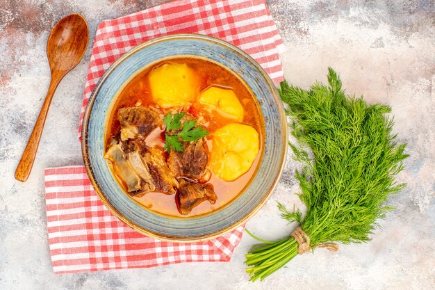 Vista superior, sopa bozbash caseira, toalha de cozinha, um monte de colher de endro na superfície nua