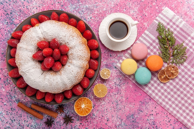Vista superior torta de açúcar em pó e bolo de morango com macarons rosa claro