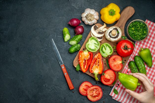 Vista superior vegetais tomates pimentões na tábua de cortar