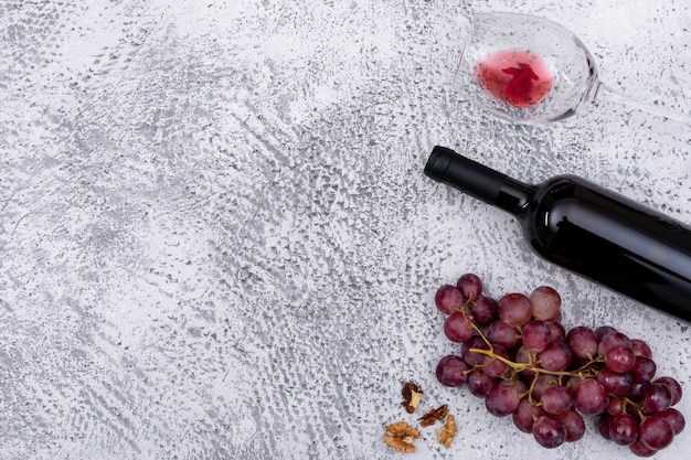 Vista superior vinho tinto com uva com espaço de cópia à esquerda na pedra branca horizontal