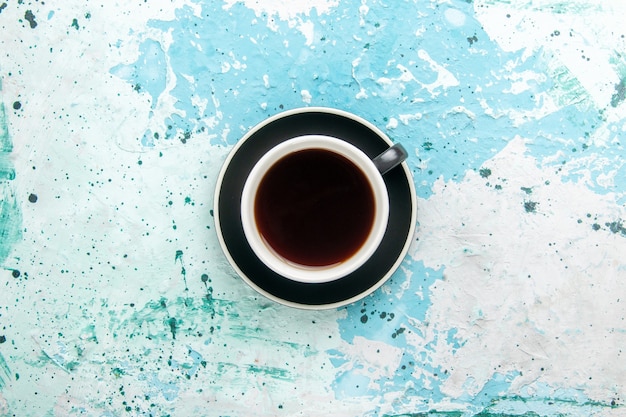 Vista superior xícara de chá bebida quente dentro do copo e prato na superfície azul