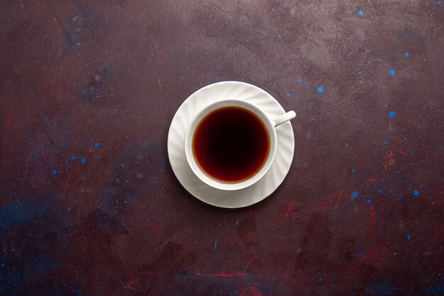 Vista superior xícara de chá dentro do prato e xícara em fundo escuro chá bebida foto colorida doce