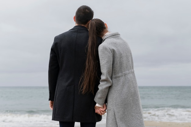 Foto grátis vista traseira casal romântico de mãos dadas