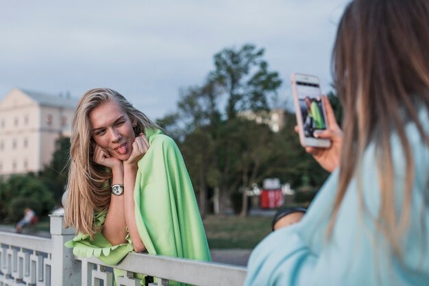 Vista traseira da câmera fotografando uma jovem mulher