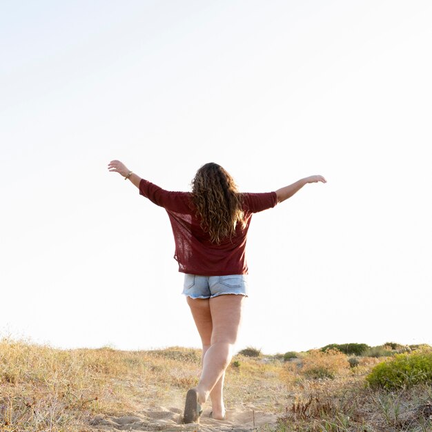 Vista traseira da mulher posando ao ar livre na natureza, com espaço de cópia