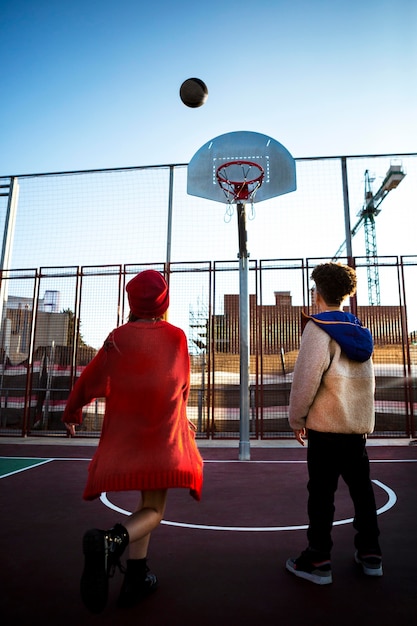 Vista traseira de crianças jogando basquete juntas ao ar livre