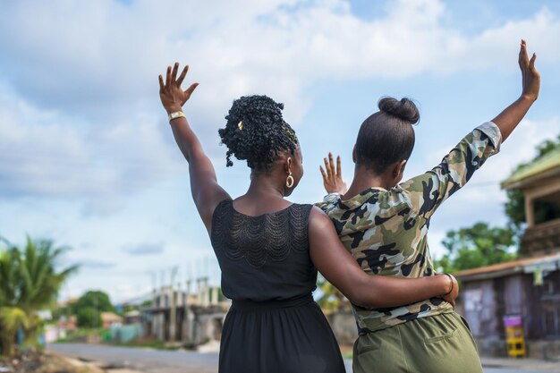 Vista traseira de duas jovens negras comemorando e abraçando