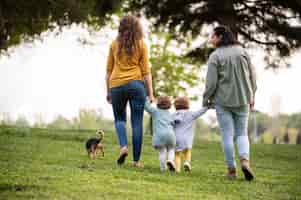 Foto grátis vista traseira de mães lgbt no parque com seus filhos e cachorro