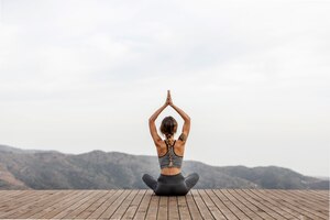 Vista traseira de mulher fazendo ioga ao ar livre