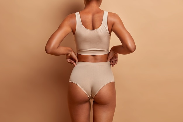 Vista traseira de poses de mulher magra sensual de calcinha e top
