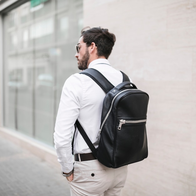 Foto grátis vista traseira, de, um, turista masculino, com, mochila preta