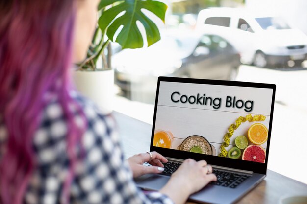 Vista traseira de uma jovem assistindo ao vídeo do blog sobre alimentação saudável no laptop