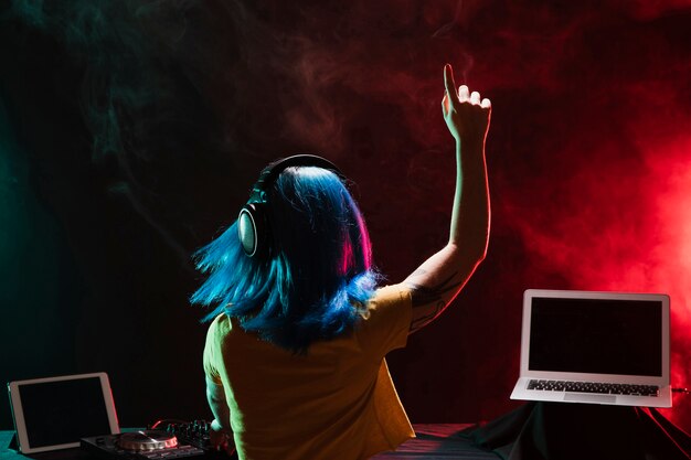 Vista traseira dj feminino em monitores