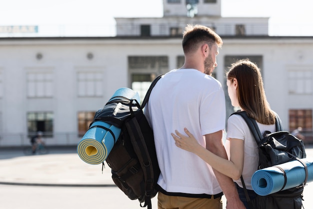 Vista traseira do casal de turistas ao ar livre com mochilas