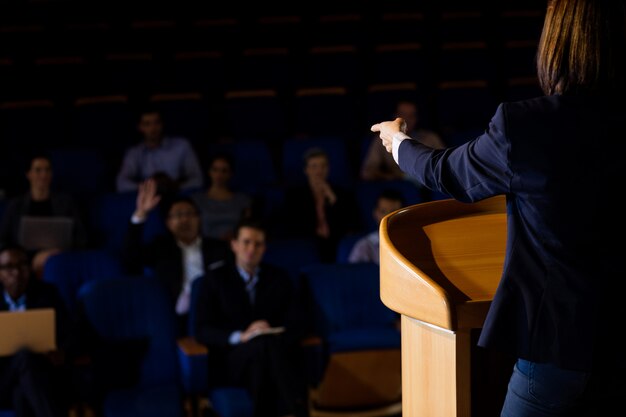 Vista traseira do executivo de negócios feminino, dando um discurso