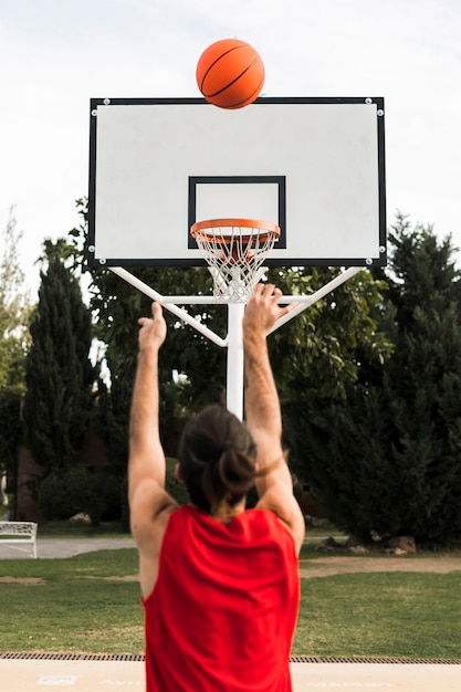 Foto grátis vista traseira do garoto jogando basquete