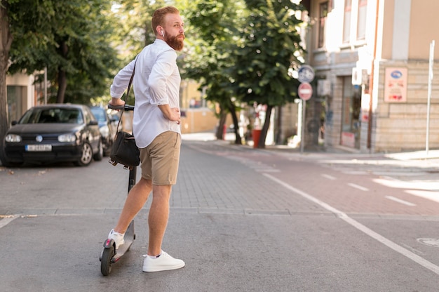 Vista traseira do homem moderno em scooter