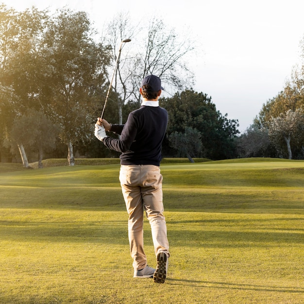 Vista traseira do homem no campo de golfe gramado