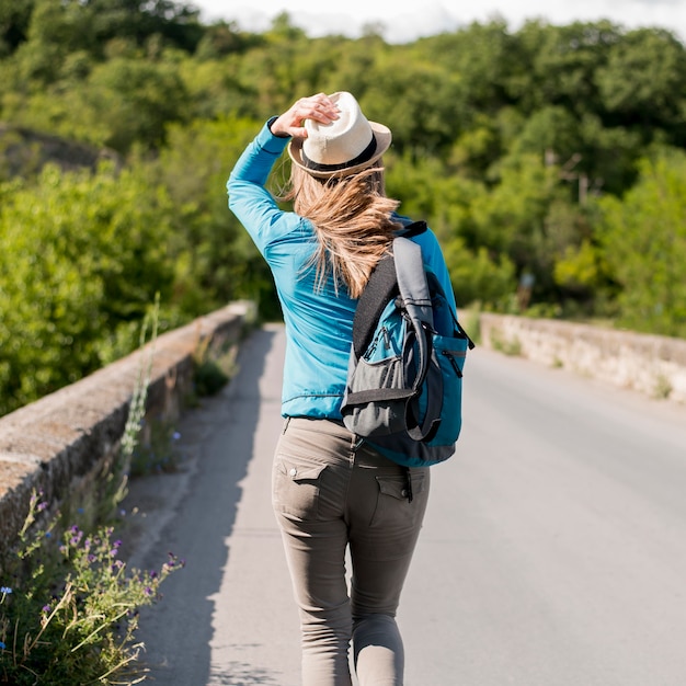 Foto grátis vista traseira elegante viajante com chapéu e mochila