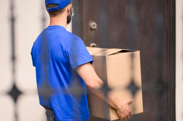 Vista traseira entrega homem carregando remessa