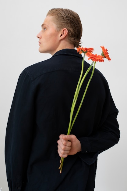 Foto grátis vista traseira homem posando com flores