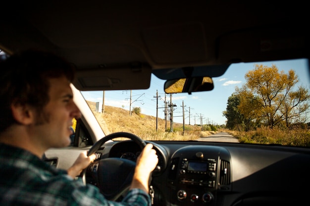 Foto grátis vista traseira masculino motorista segurando o volante