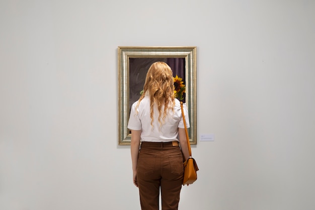 Foto grátis vista traseira mulher admirando a pintura