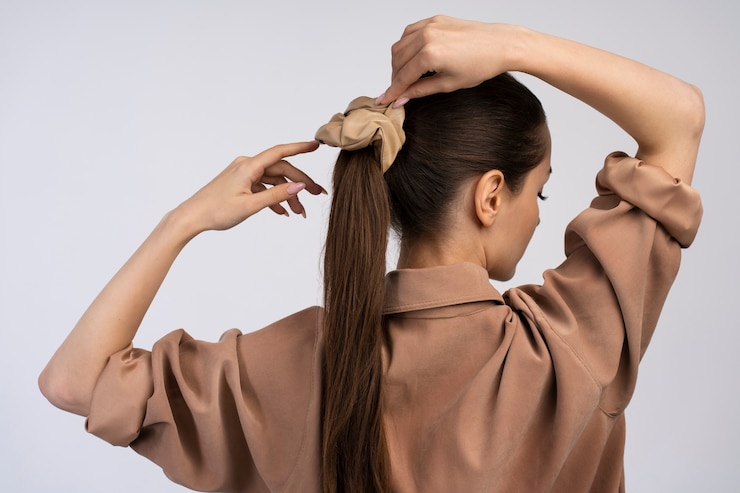 Foto grátis vista traseira mulher amarrando o cabelo