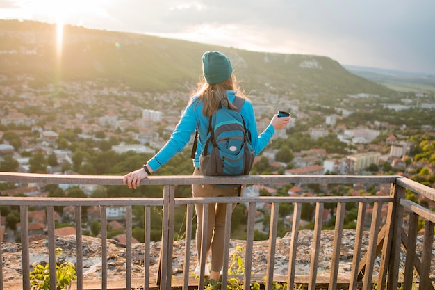 Vista traseira viajante com gorro curtindo férias