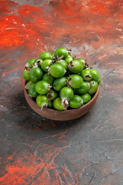 Vista vertical de uma pequena bomba de vitaminas feijoas frescas em uma panela marrom