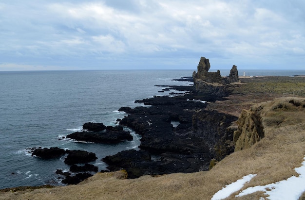 Vistas panorâmicas da formação rochosa de lava de Londrangar ao longo da costa da Islândia.