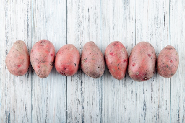 Foto grátis visualização horizontal de batatas no fundo de madeira com espaço de cópia