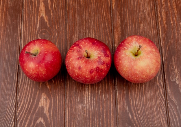visualização horizontal de maçãs vermelhas em fundo de madeira