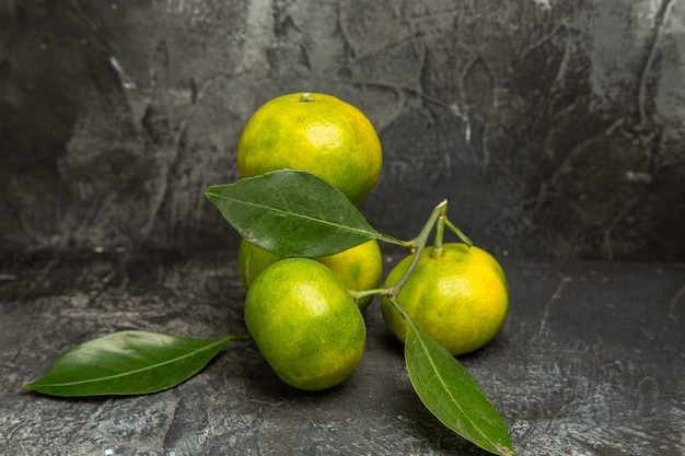 Visualização horizontal de tangerinas verdes frescas com folhas em imagens de fundo cinza