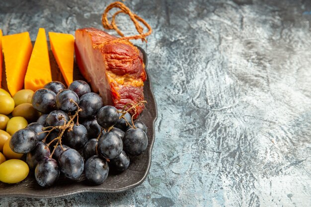 Visualização horizontal do delicioso melhor lanche para vinho na bandeja marrom no fundo de gelo