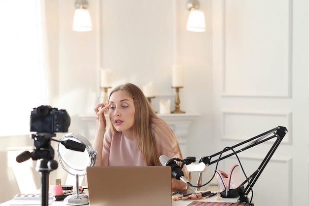 Vlogger de beleza. jovem gravando um tutorial de maquiagem