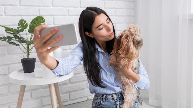 Foto grátis vlogger feminina em casa com smartphone